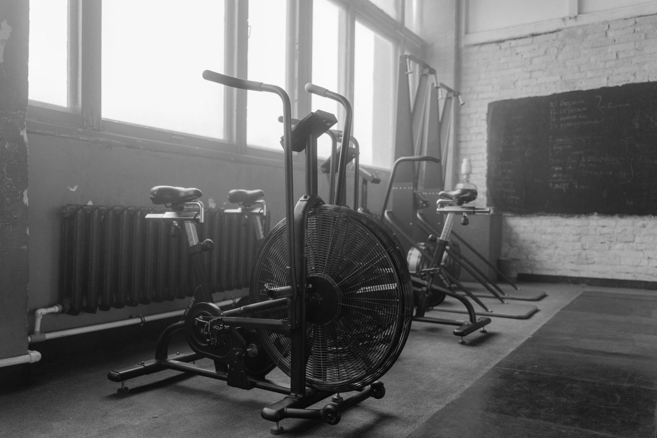 services-03 Black and white gym interior featuring exercise bikes and fitness equipment.
